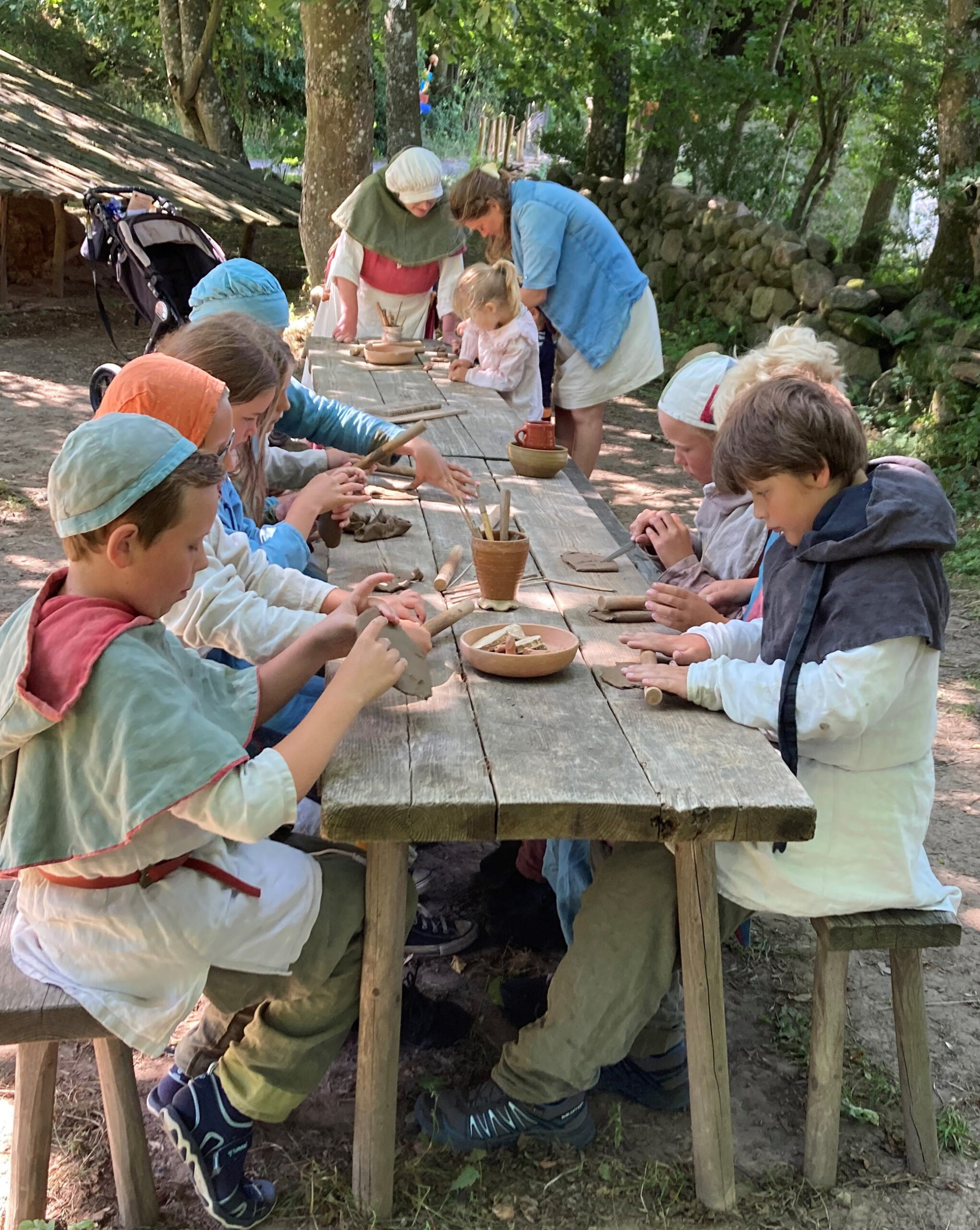 Children building objects from clay with a teacher in Bornholm's Medieval Centre.