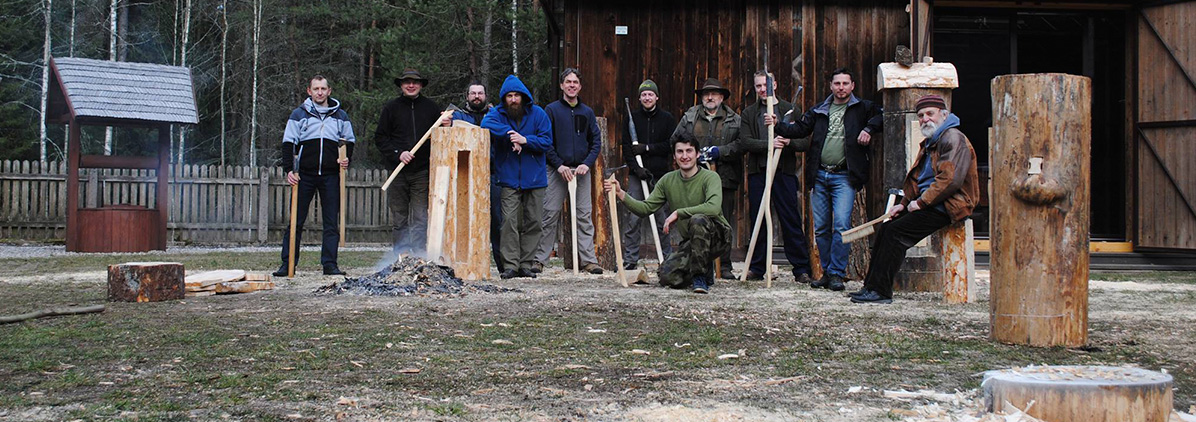 A group of men with bee nests hollowed from tree trunks pose to the photographer